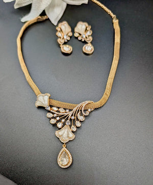 Gold necklace and earrings set on a dark surface
